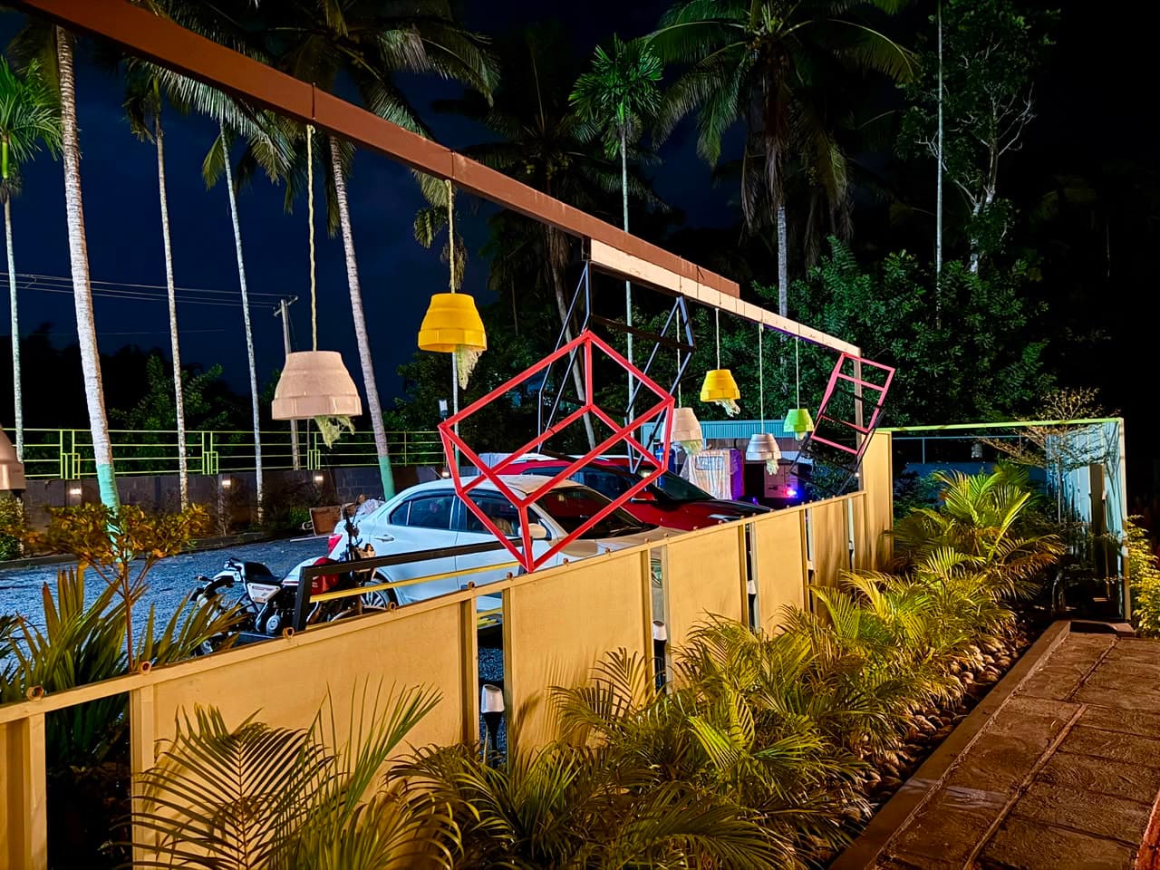 Hanging lamps over the parking area under the coconut palms at night