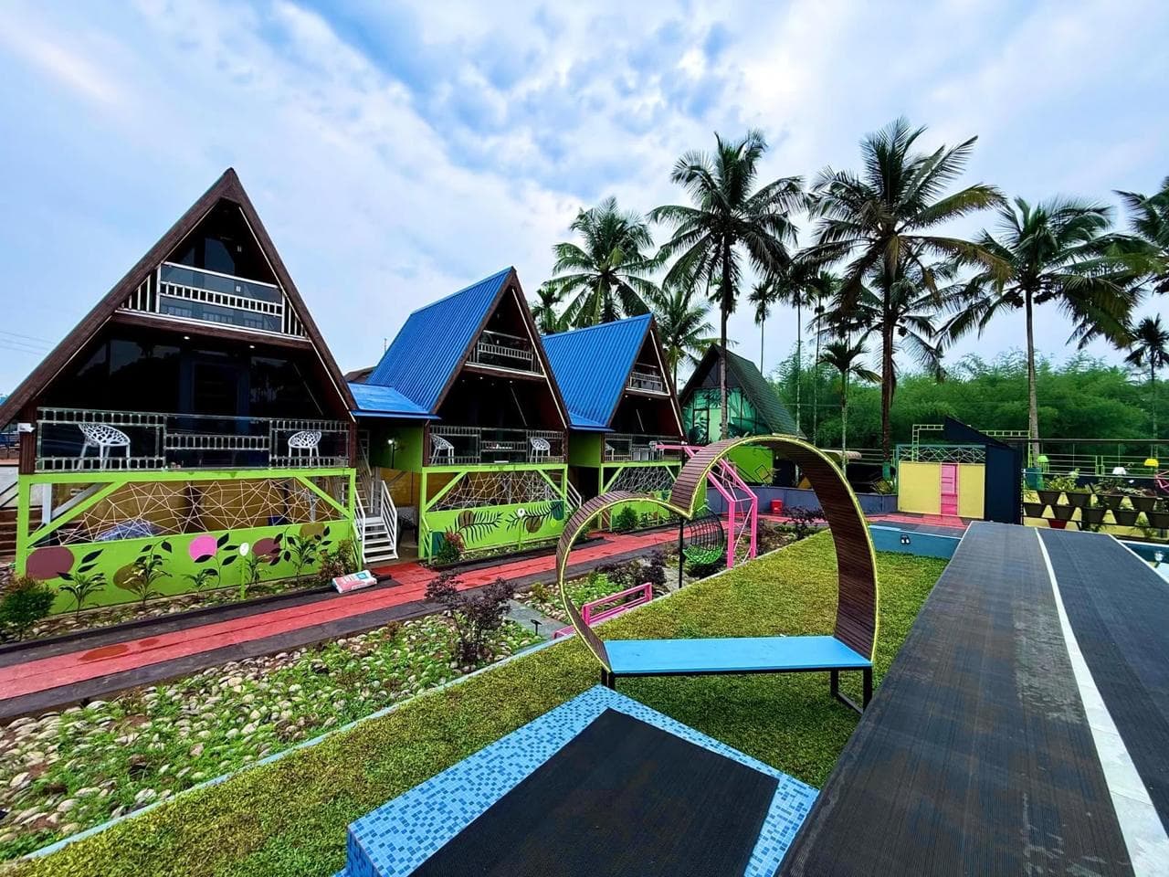 The chalets, the deck and the planted grounds on a bright morning