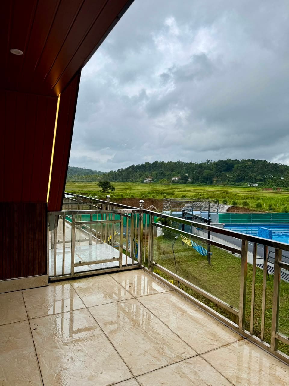 The scenic morning view from a chalet deck at Mist Wave Resort Wayanad over paddy fields